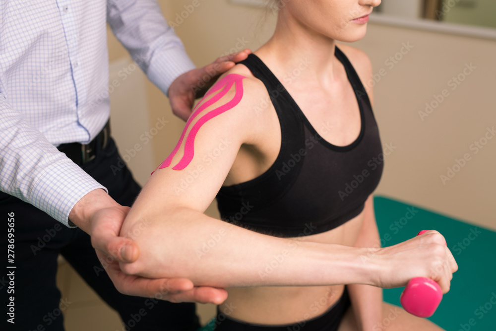 Physiotherapist doing shoulder exercises with patient Physiotherapist doing shoulder exercises with patient