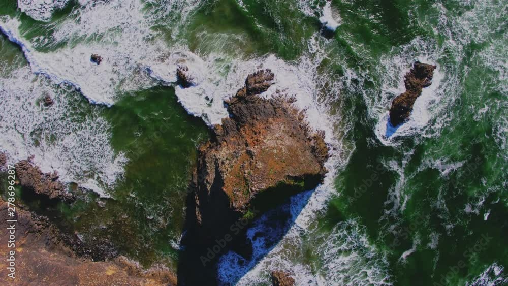 Aerial descending above ocean rock, breaking waves patterns, textures Aerial descending above ocean rock, breaking waves patterns, textures