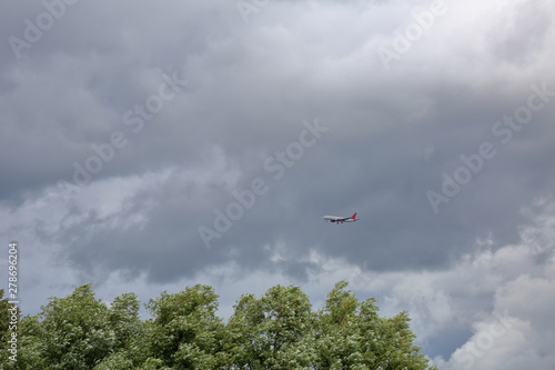 A large civil aviation aircraft flies in the sky in cloudy weather