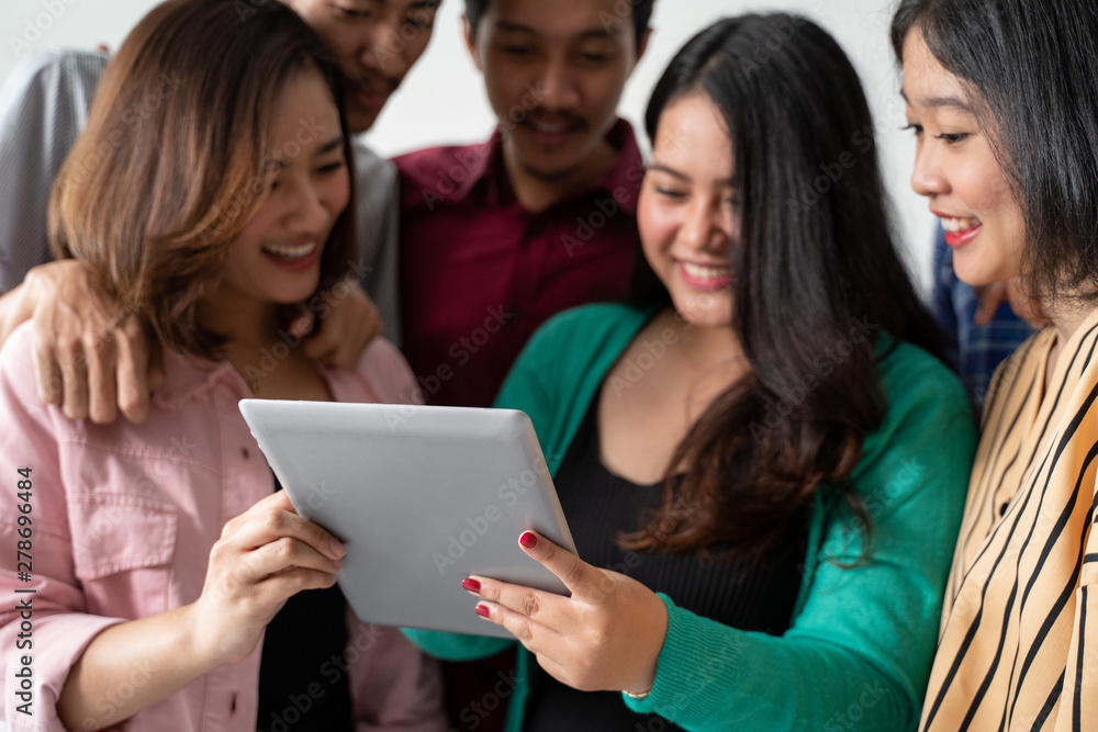 the woman and her friend hold the tablet to see the news the woman and her friend hold the tablet to see the news