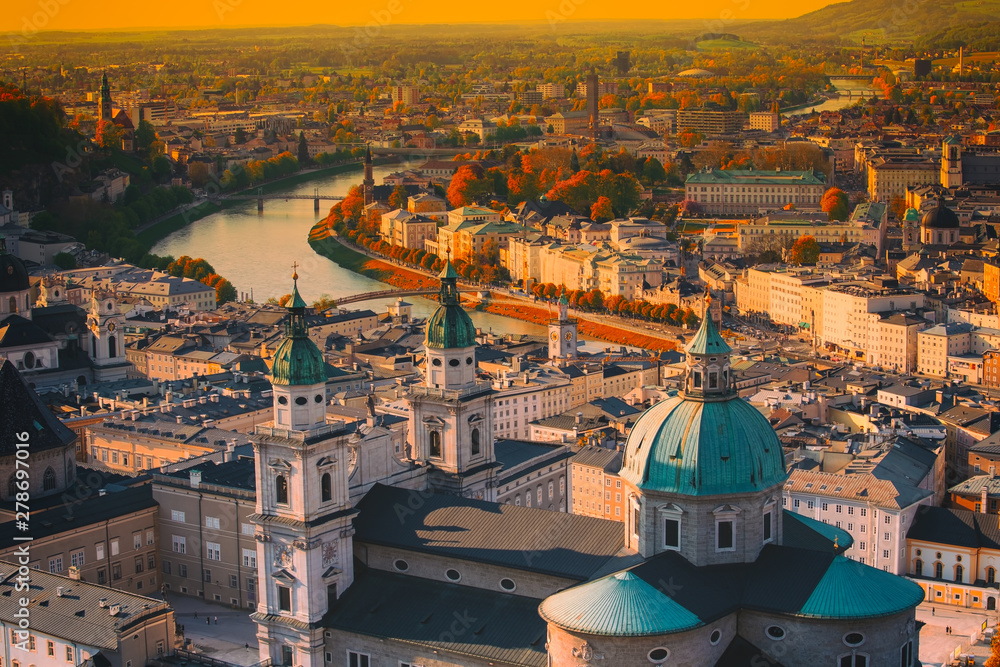Fototapeta premium Piękny widok z lotu ptaka w sezonie jesiennym w historycznym mieście Salzburg z rzeką Salzach w pięknym złotym wieczornym świetle nieba i kolorowej jesieni o zachodzie słońca, Salzburger Land, Austria