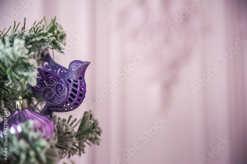 Christmas picture in pink, purple, neon color close up. Scandinavian style of decorating the Christmas tree. Christmas toys such as birds, flowers, garlands, copy space.