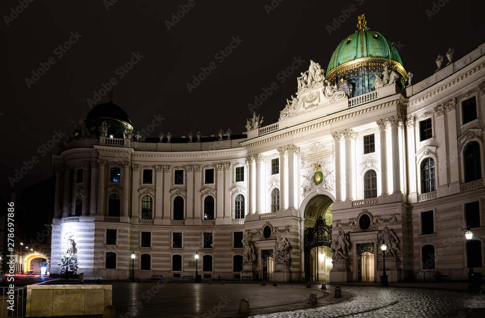 The Hofburg Palace in Vienna, ancient baroque imperial palace. Entrance of the Saint Michael wing in Michaelerplatz square at night