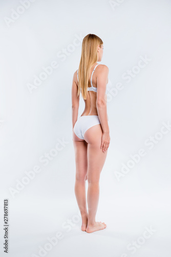 Vertical full length body size half-turned view of nice attractive lovely skinny thin sportive candid girl perfect figure shape form line standing straight isolated over light gray background © deagreez