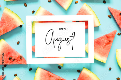 Inscription Happy August. Fresh red watermelon slice Isolated light blue background. Top view, Flat lay. - Image photo