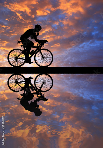 Silhouette  Cycling  on blurry sunrise  sky   background. © rathchapon