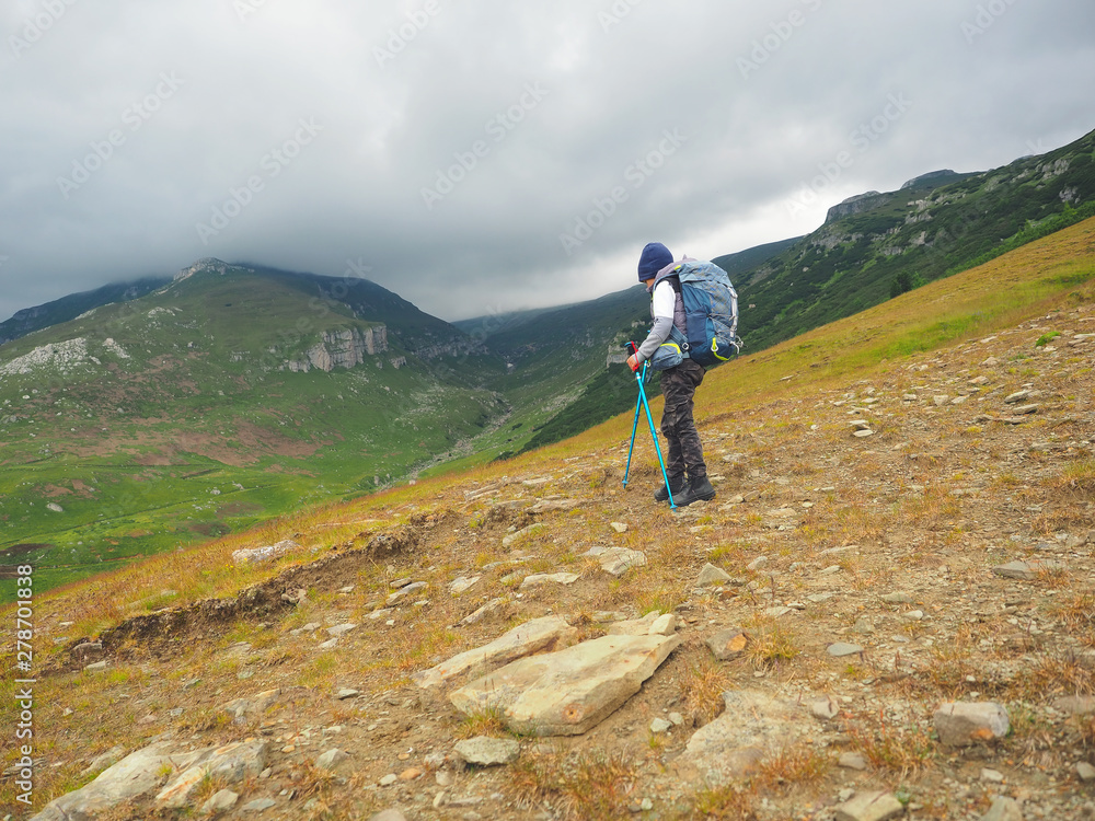 Little boy with backpack hiking in scenic mountains Little boy with backpack hiking in scenic mountains
