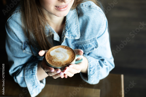young girl smiling and drinking delicious coffee