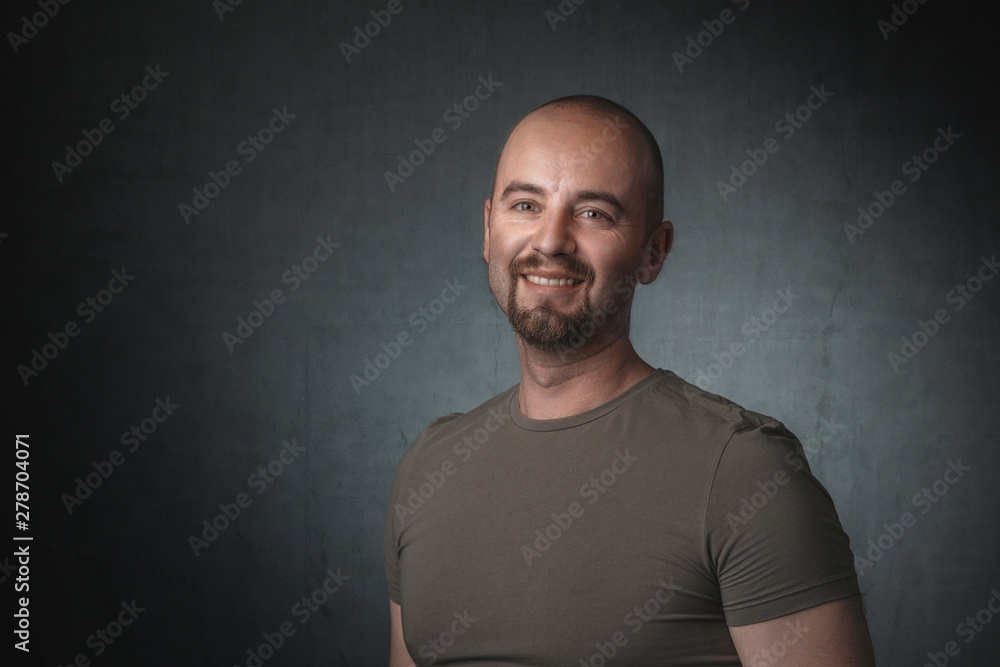 portrait of smiling caucasian man with t-shirt and dark background.