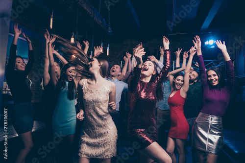 Nice-looking attractive smart glamorous cheerful cheery glad positive stylish chic ladies and gentlemen having fun solemn festal festive fest feast in fashionable luxury place nightclub indoors