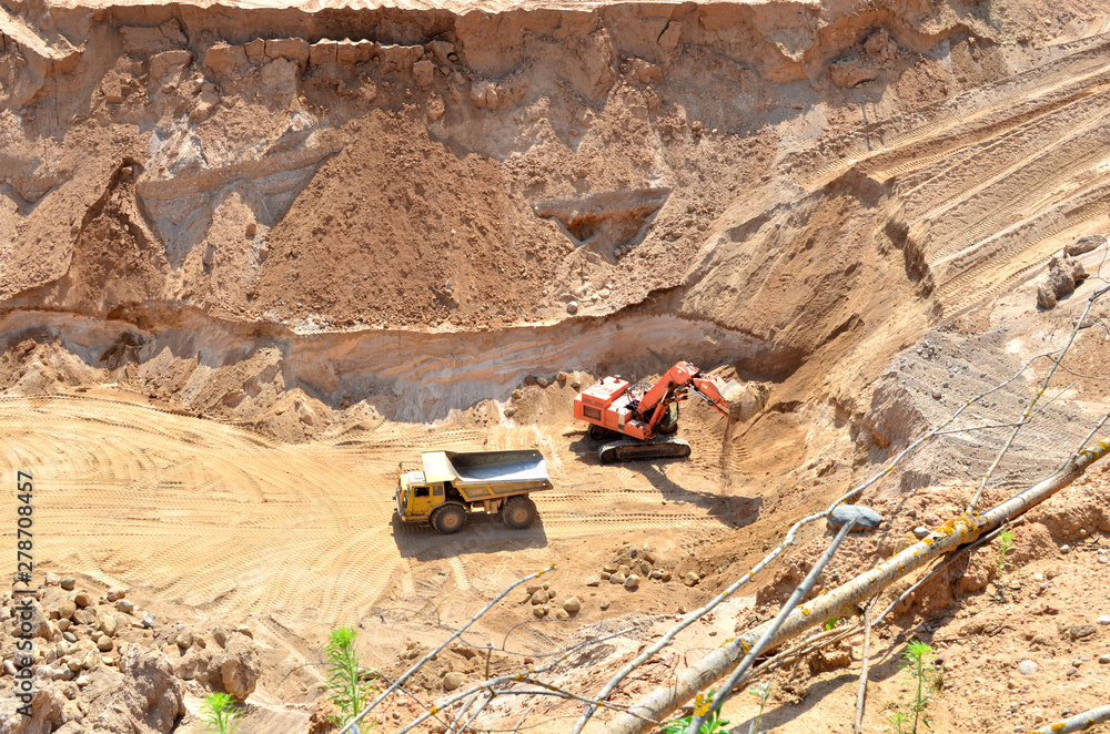 Excavator developing the sand on the opencast and loading it to the heavy dump truck. Processing of loose material in mining quarry. Drill, breaking, processing plant, crushing and screening - Image Excavator developing the sand on the opencast and loading it to the heavy dump truck. Processing of loose material in mining quarry. Drill, breaking, processing plant, crushing and screening - Image