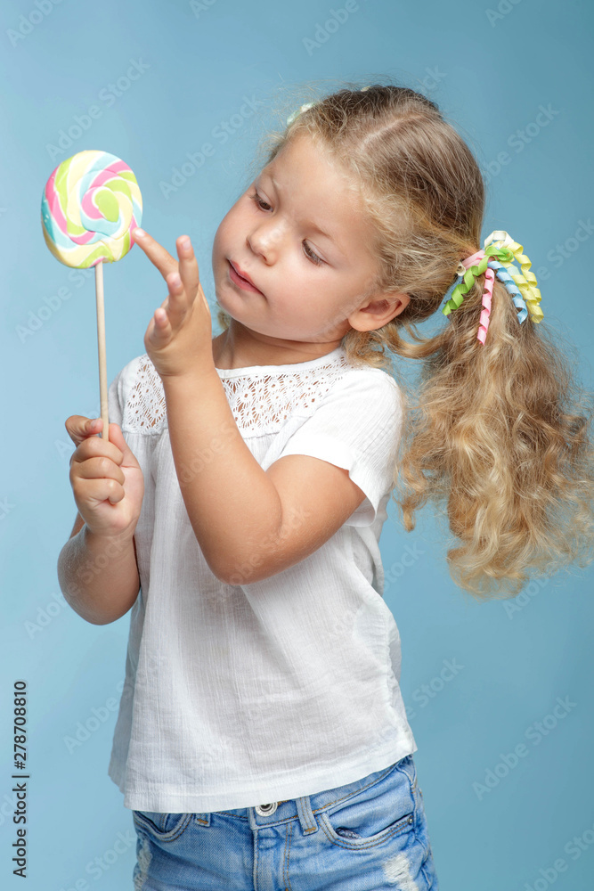 A little girl is holding candy in her hands. A little girl is holding candy in her hands.