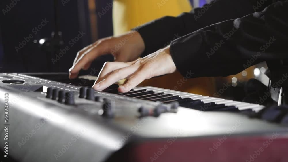 The musician plays the synthesizer during the performance. The musician plays the synthesizer during the performance.