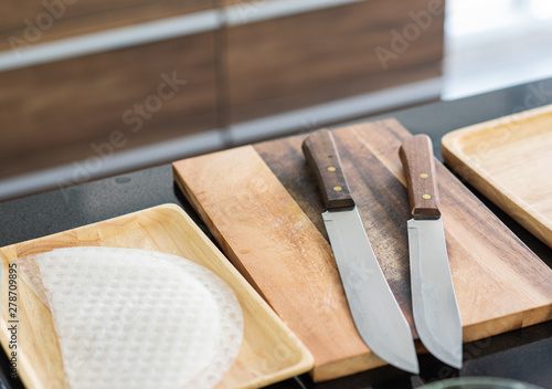 Cutting board with sharp stainless knife in modern kitchen background