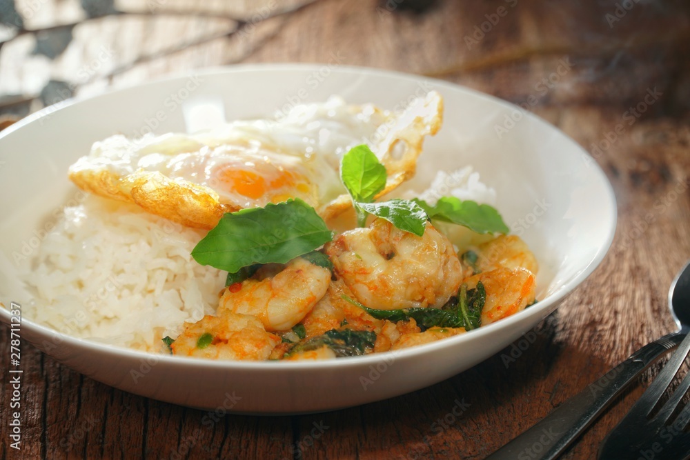 Thai food : Kaphrao Kung is Stirred and fried shrimps with holy basil and chilies served on steamed rice and fried egg. Shooting in studio for advertising. Thai and Asian food concept. Thai food : Kaphrao Kung is Stirred and fried shrimps with holy basil and chilies served on steamed rice and fried egg. Shooting in studio for advertising. Thai and Asian food concept.