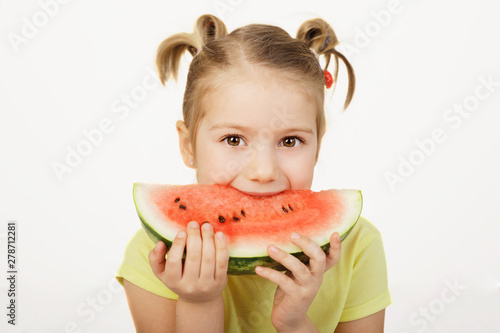 Little 5 year old girl eating slice of the watermelon, idea of healthy eating habits and summer time 