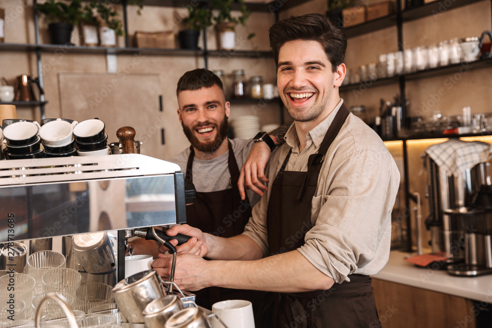 © Drobot Dean - Group of cheerful men baristas wearing aprons