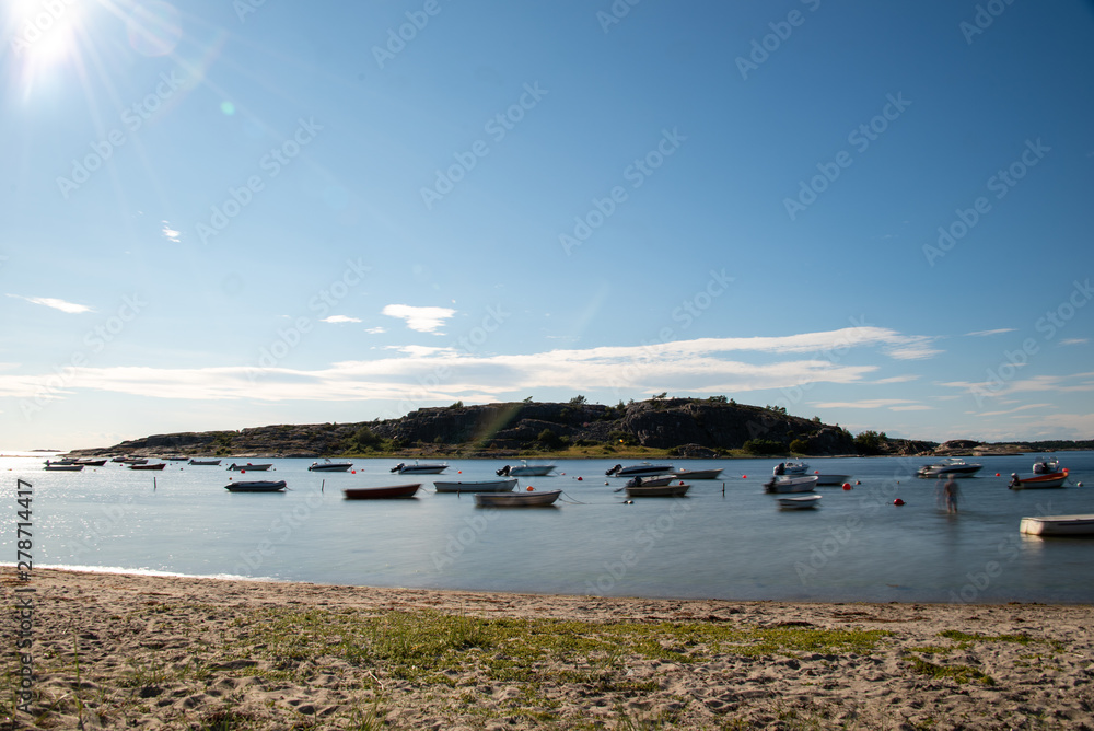 Resö, Sweden - July 15, 2019: View of small boats and a rock off the island of Resö in western Sweden. Land time exposure. Shake effects.