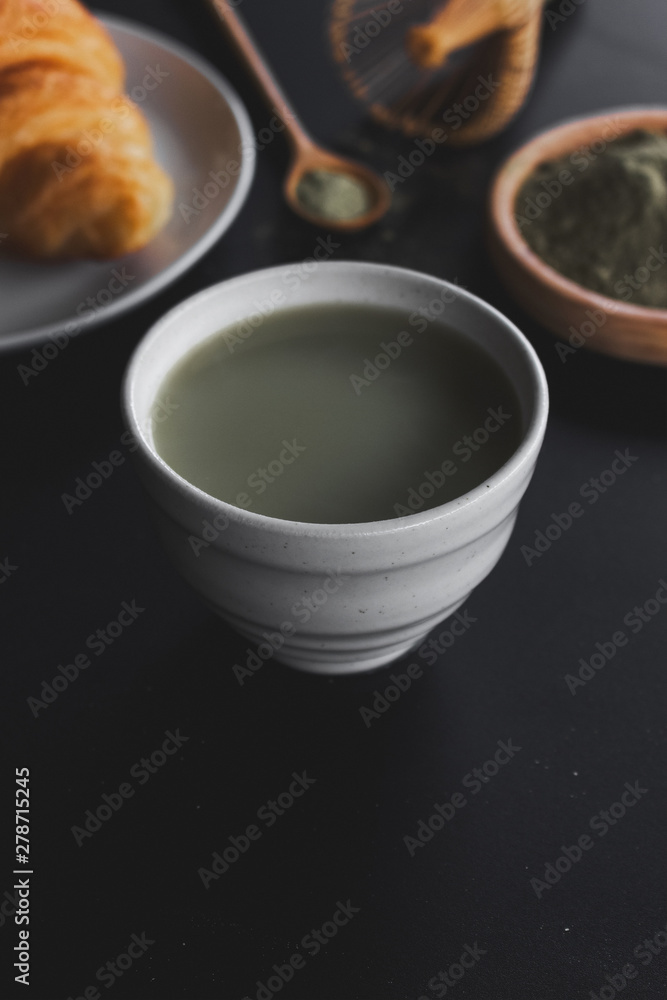 matcha green tea latte on black table with soft-focus and over light in the background matcha green tea latte on black table with soft-focus and over light in the background