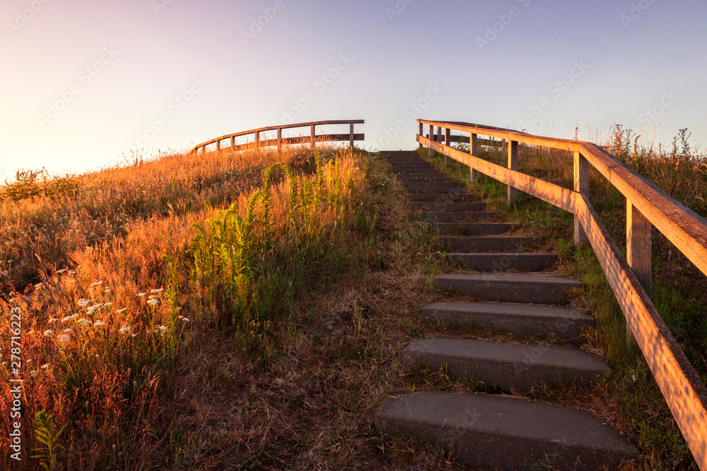 These stairs leads to the viewing point called Distelbelt. It is located in the eastern Netherlands near the valley of the river Vecht (Vechtdal in Dutch) where the sun is setting on a June evening.