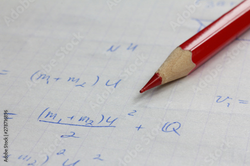 red pencil on the background of mathematical formulas in notebook. work on the bugs