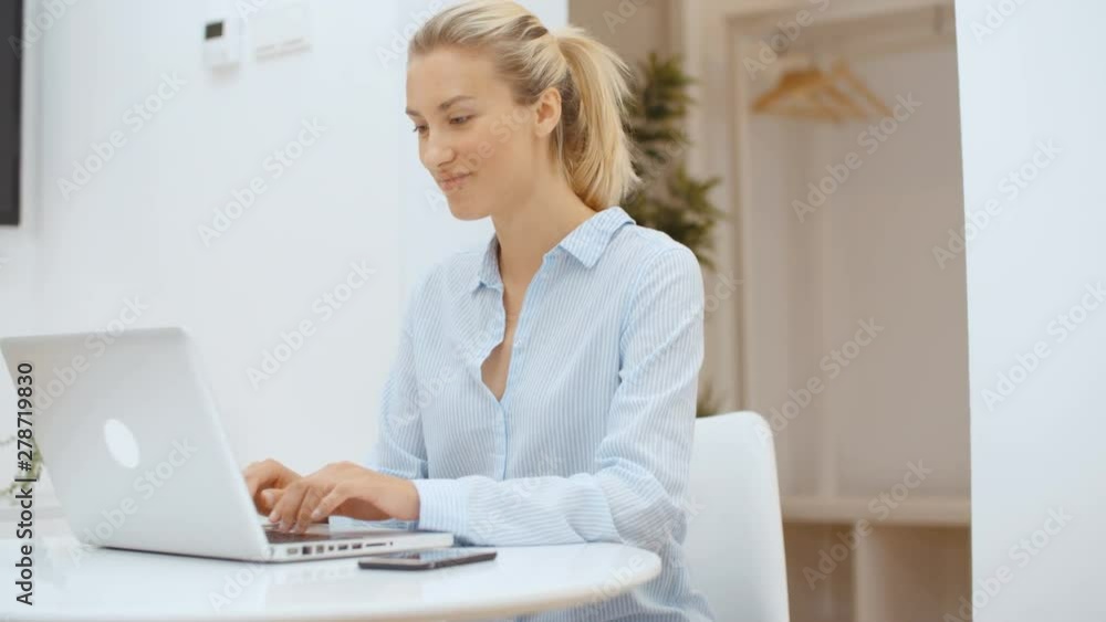 Young woman working on her laptop computer and using smartphone at home. Young woman working on her laptop computer and using smartphone at home.