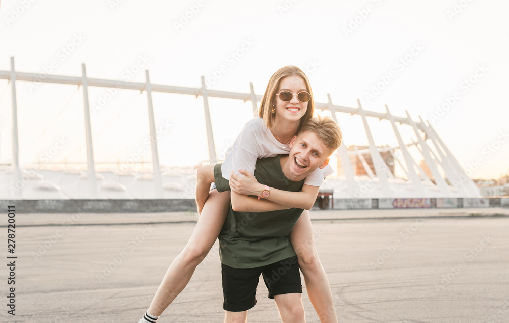 Cheerful woman holding on to boyfriends head while having piggyback ride  stock photo