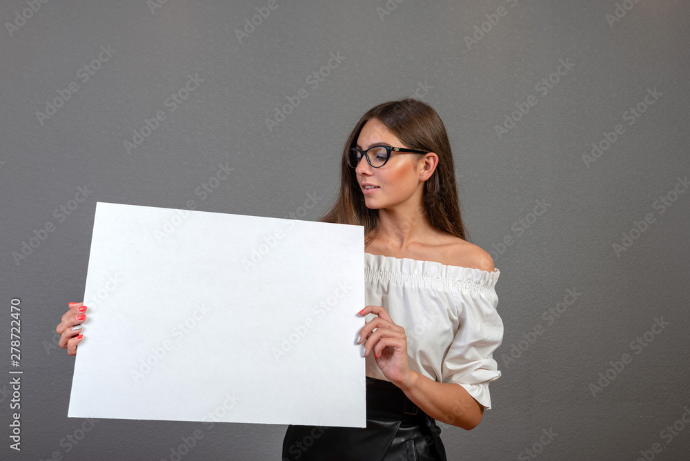Beautiful woman holding a blank billboard isolated on gray background - inage Beautiful woman holding a blank billboard isolated on gray background - inage