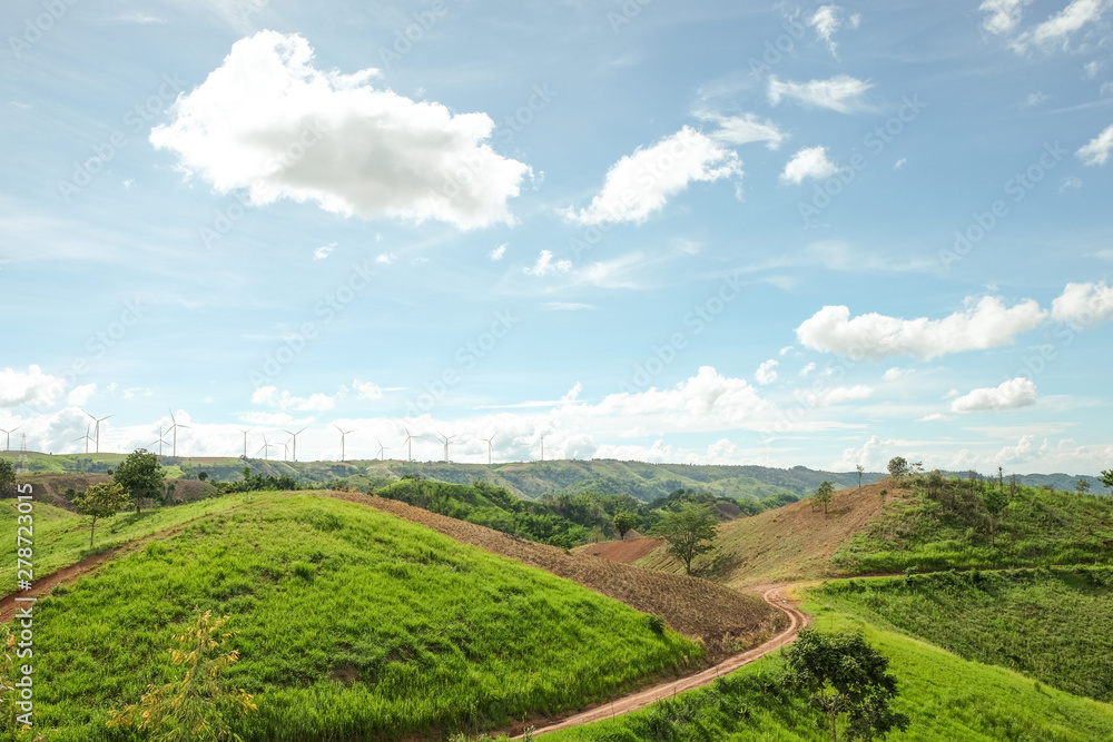 electricity production using wind energy concept, landscape of green hills and wind turbines farm with beautiful sky background electricity production using wind energy concept, landscape of green hills and wind turbines farm with beautiful sky background
