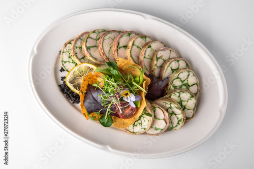 Roll of salmon and spinach. Delicate roll stuffed with fish, vegetables and herbs. Banquet festive dishes. Gourmet restaurant menu. White background.