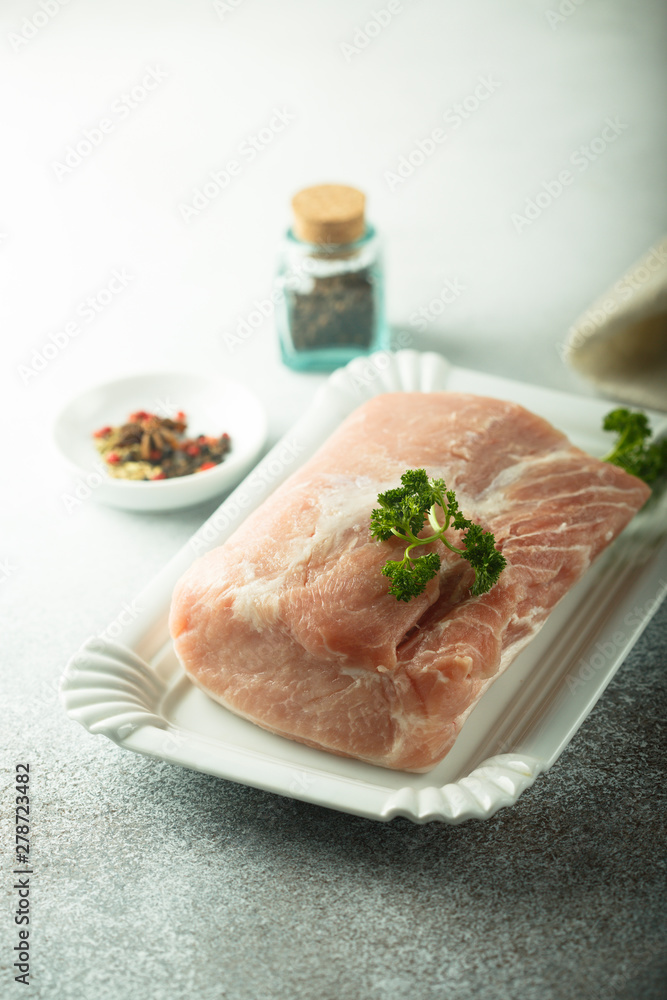 Pork tenderloin, uncooked on white plate Pork tenderloin, uncooked on white plate