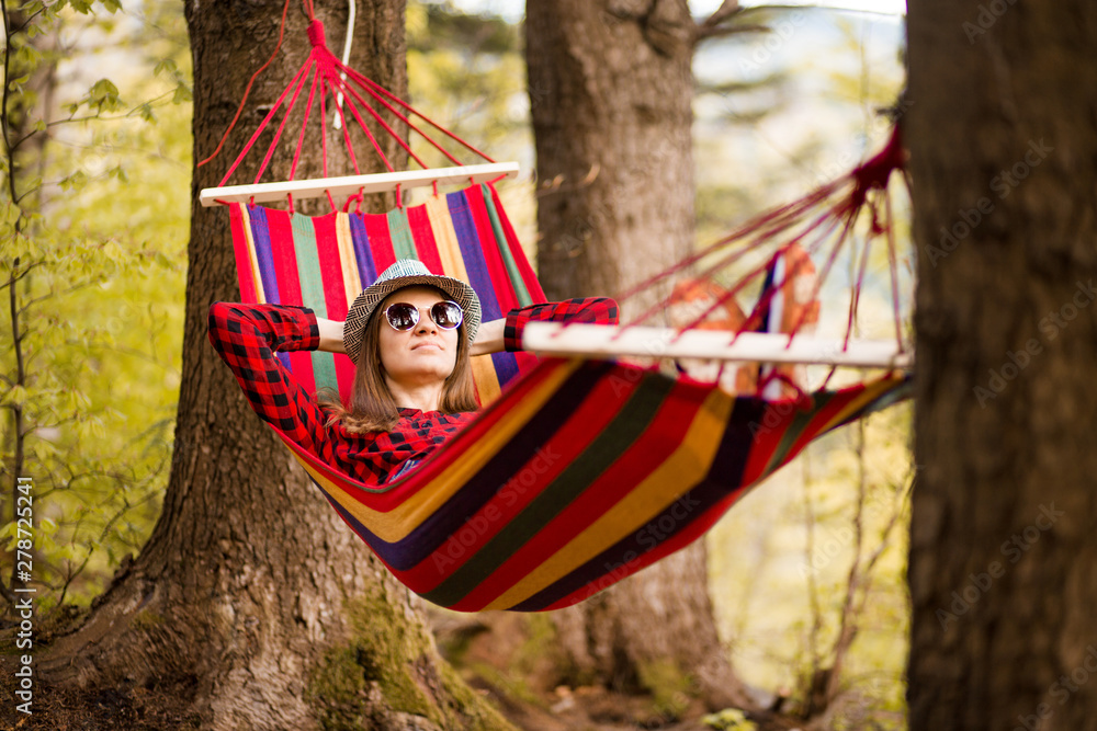 Carefree happy woman lying on hammock enjoying harmony with nature. Freedom. Enjoyment. Relaxing in forest. Daydreaming Carefree happy woman lying on hammock enjoying harmony with nature. Freedom. Enjoyment. Relaxing in forest. Daydreaming