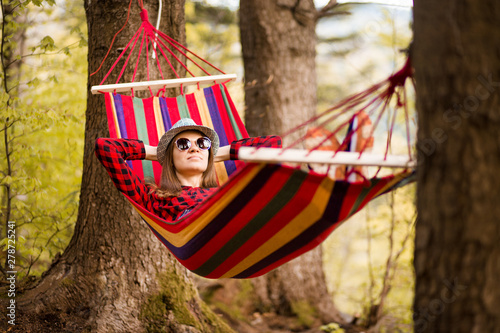 Carefree happy woman lying on hammock enjoying harmony with nature. Freedom. Enjoyment. Relaxing in forest. Daydreaming