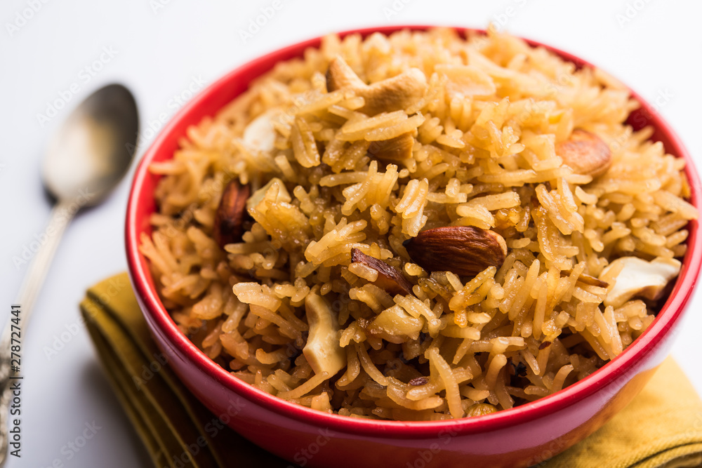 Traditional Jaggery Rice or Gur wale chawal in Hindi, served in a bowl with spoon. selective focus Traditional Jaggery Rice or Gur wale chawal in Hindi, served in a bowl with spoon. selective focus