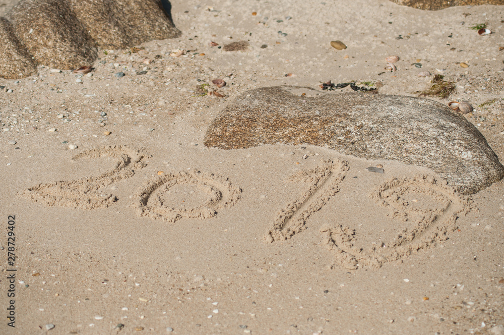 closeup of 2019 writing in the sand on the beach