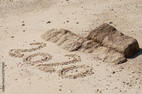 closeup of 2020 writing in the sand on the beach