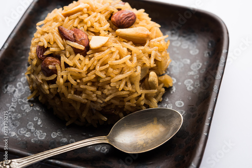 Traditional Jaggery Rice or Gur wale chawal in Hindi, served in a bowl with spoon. selective focus photo