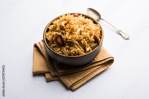 Traditional Jaggery Rice or Gur wale chawal in Hindi, served in a bowl with spoon. selective focus photo