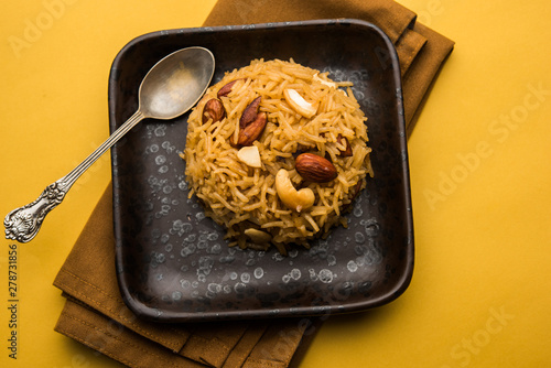 Traditional Jaggery Rice or Gur wale chawal in Hindi, served in a bowl with spoon. selective focus photo