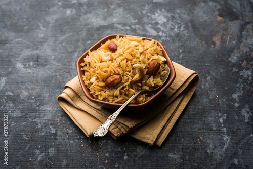 Traditional Jaggery Rice or Gur wale chawal in Hindi, served in a bowl with spoon. selective focus photo