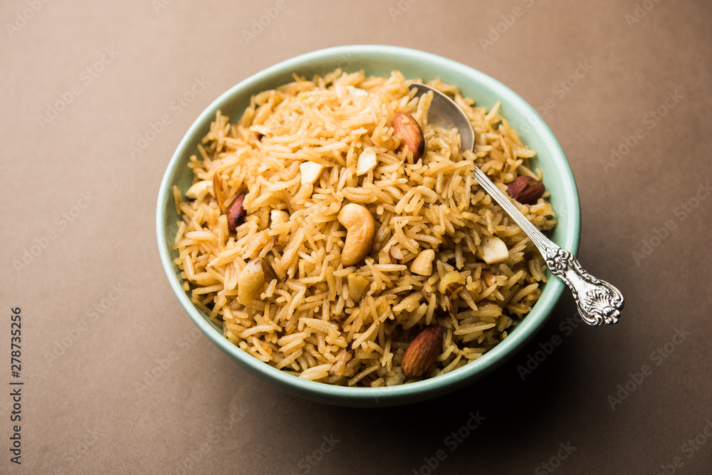 Traditional Jaggery Rice or Gur wale chawal in Hindi, served in a bowl with spoon. selective focus Traditional Jaggery Rice or Gur wale chawal in Hindi, served in a bowl with spoon. selective focus