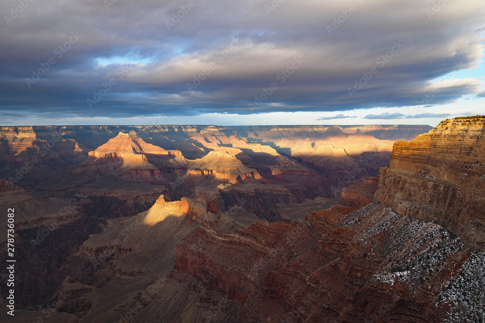 View of the Grand Canyon under a complex cloudscape from the South Rim Trail in Grand Canyon National Park, Arizona, in winter.