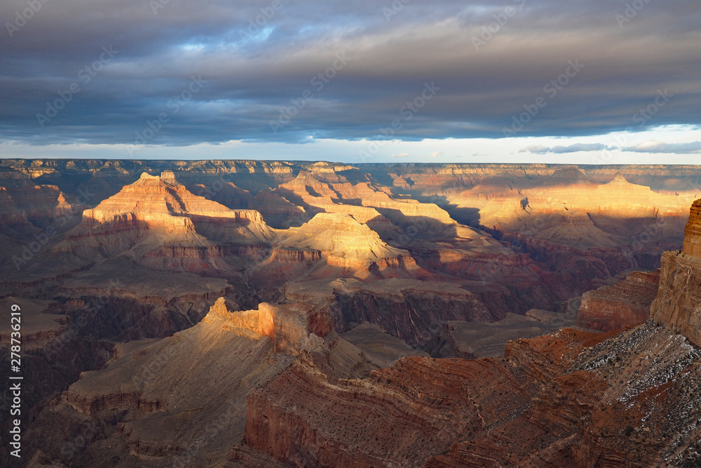 View of the Grand Canyon under a complex cloudscape from the South Rim Trail in Grand Canyon National Park, Arizona, in winter.