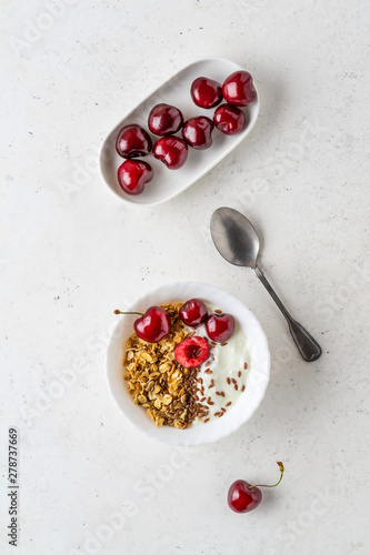 Healthy breakfast with greek yogurt, granola (muesli), flax seeds, cherries. Health care, fitness, diet concept.