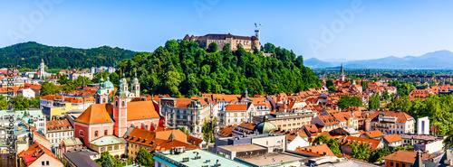 Fotografiet Old town and the medieval Ljubljana castle on top of a forest hill in Ljubljana,