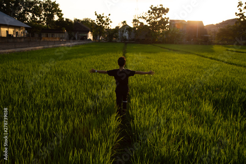 Asian Man Stretches in the Rice Fields at the Sunset