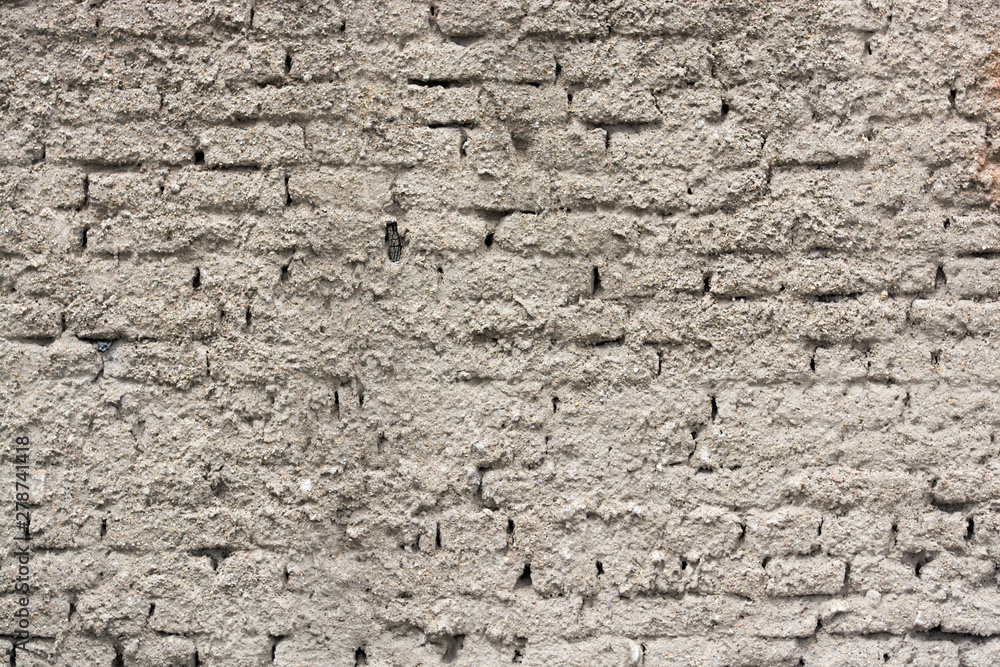 Grey stucco grungy wall surface covering brick tile pattern Grey stucco grungy wall surface covering brick tile pattern