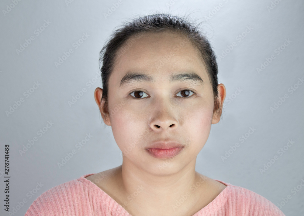 Portrait beautiful face of young woman with being serious in pink shirt on grey background. Portrait beautiful face of young woman with being serious in pink shirt on grey background.