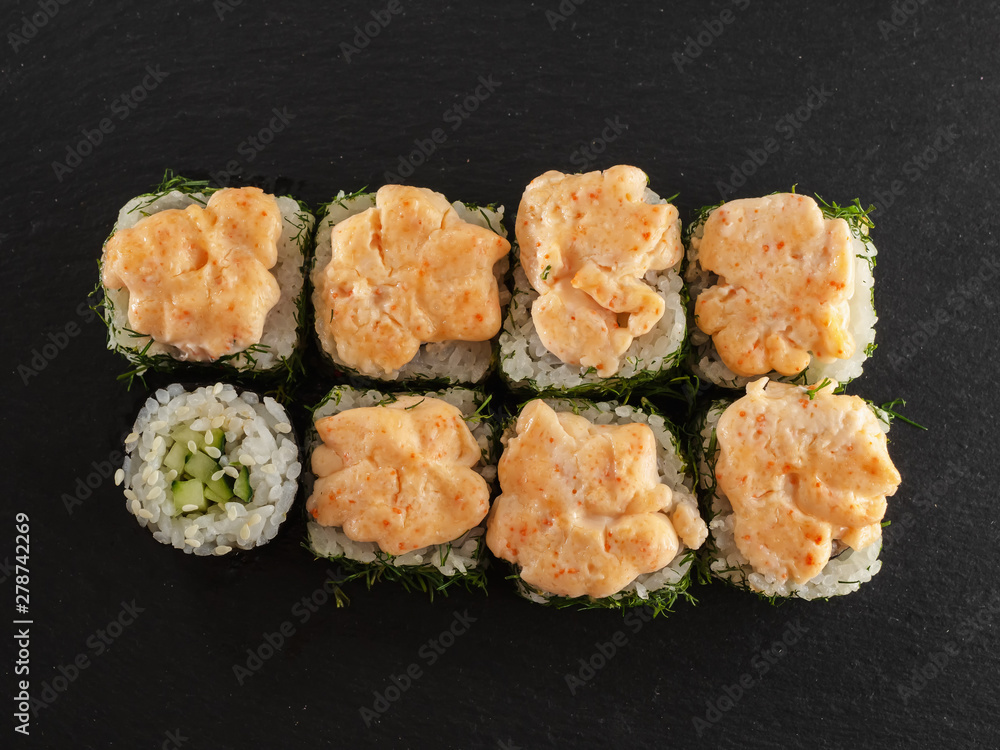 sushi rolls on gray stone slate on wood background sushi rolls on gray stone slate on wood background
