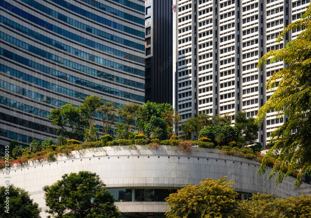 Modern glass buildings with garden and trees on roof in Singapore Modern glass buildings with garden and trees on roof in Singapore